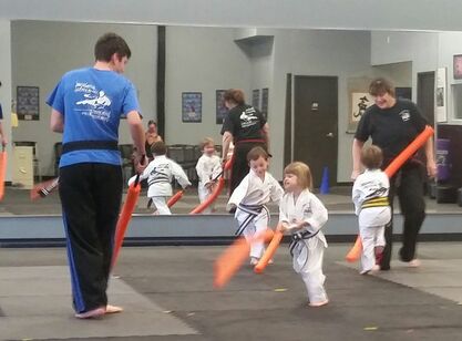 Kids play a karate game with instructors